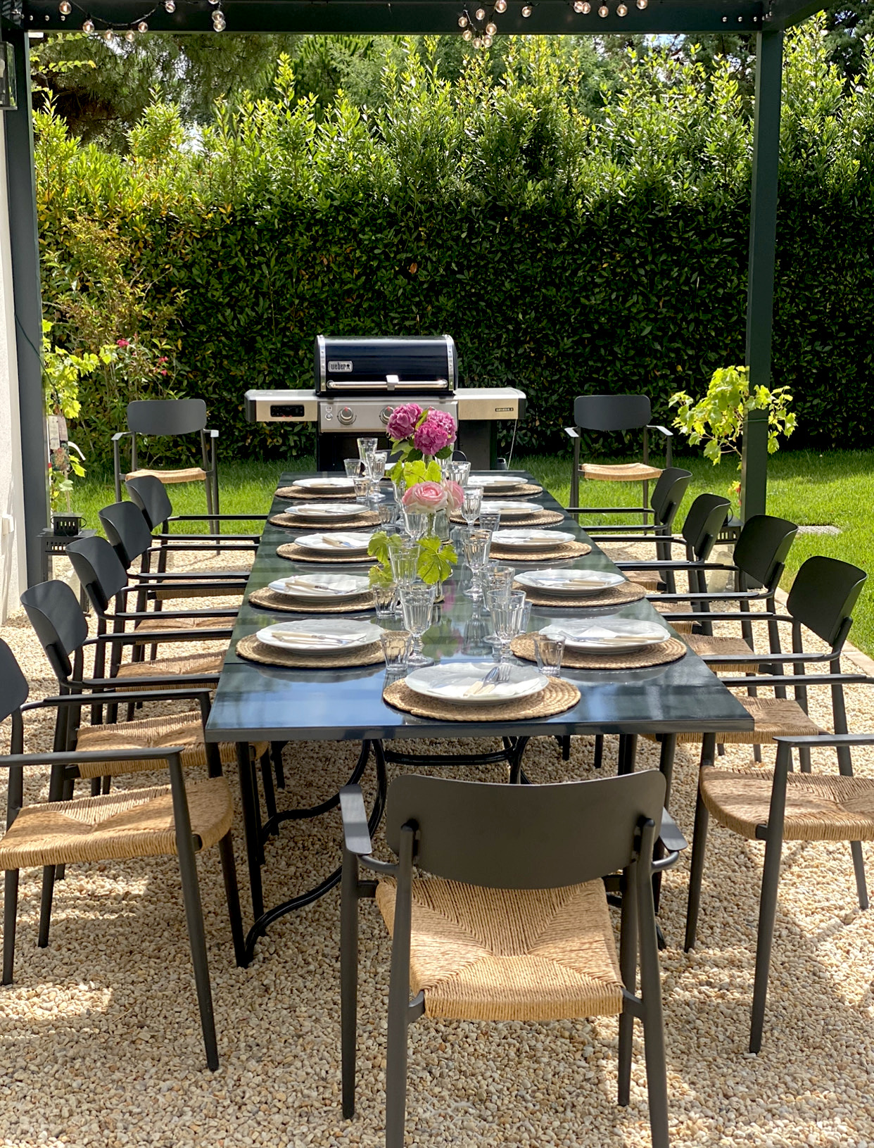 Vertical Image of Dining Pergola with table set and BBQ in the background