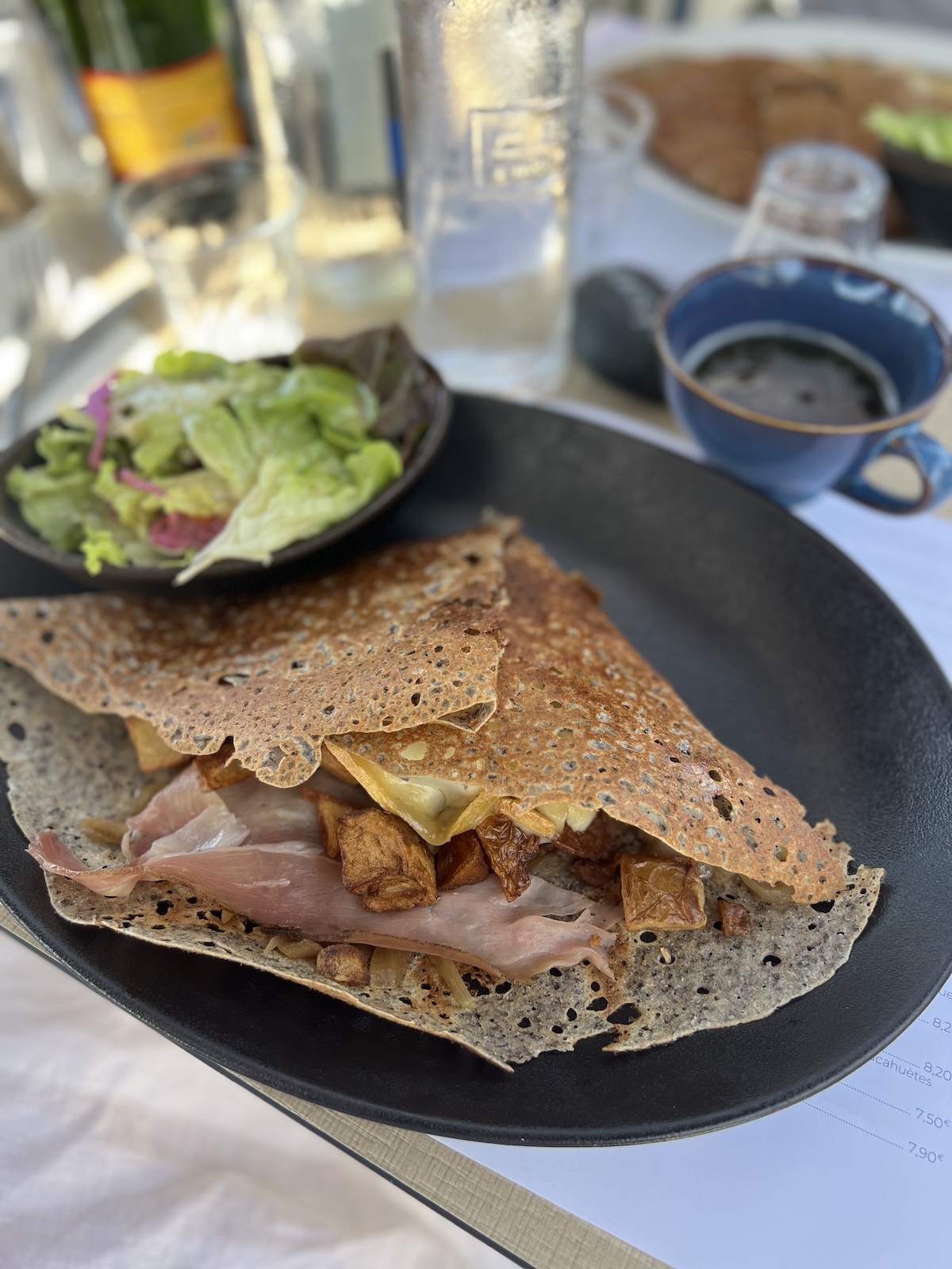 Galette and cider on a plate with salad