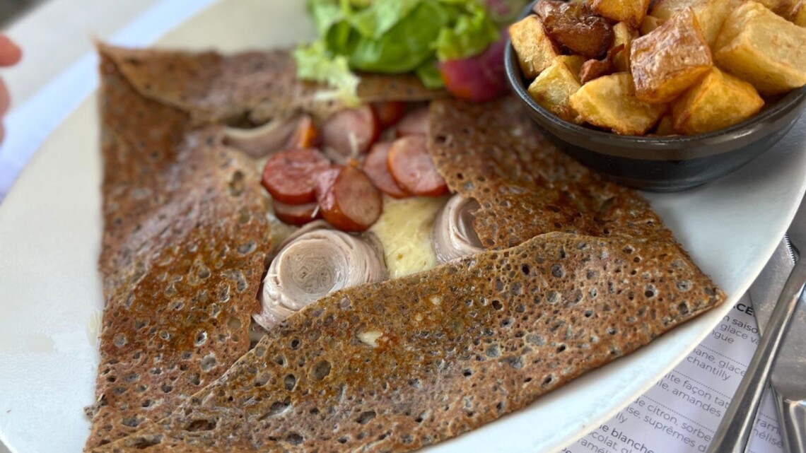 Galette on a plate with salad and potatoes