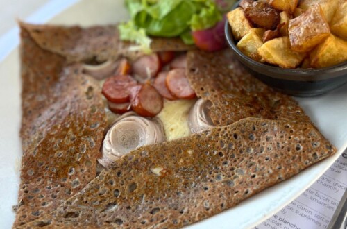 Galette on a plate with salad and potatoes
